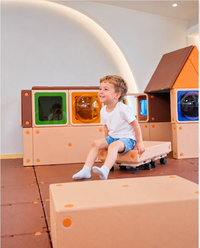 Two young children exploring tactile discrimination and stacking blue ribbed sensory blocks on Egoo TiniTerra play table