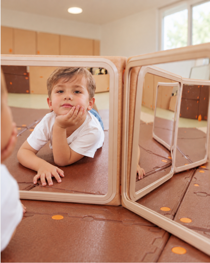 Child playing actively around Egoo Cosmotor modular playhouse featuring colorful sensory bubble observation windows