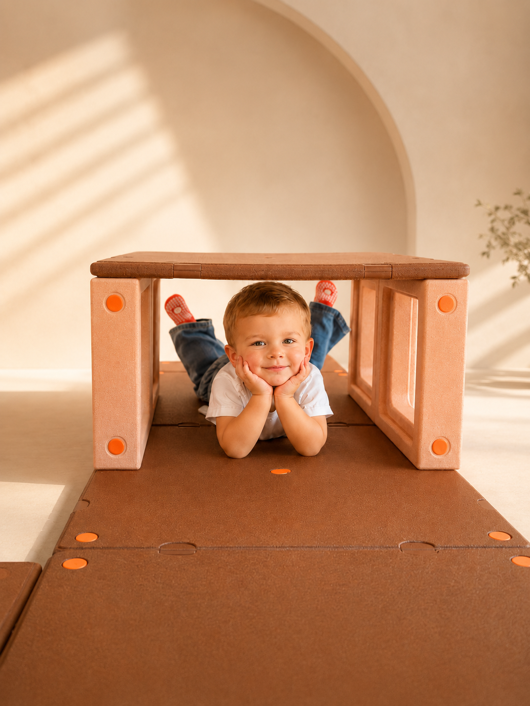 Toddler boy developing gross motor balance and coordination by climbing over gentle incline soft foam wedges on Egoo TiniTerra floor mats.
