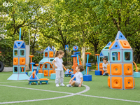 Young student playing hopscotch on an outdoor balance course made of Egoo Magniworld magnetic modular tiles next to a rocket tower.