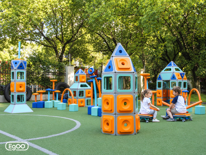 Full view of kindergarten playground with life-size rocket towers, playhouses, and balance structures built with Egoo Magniworld magnetic blocks.