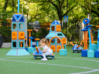Children interacting and riding on rolling scooter carts assembled from Egoo Magniworld modular magnetic components outdoors.
