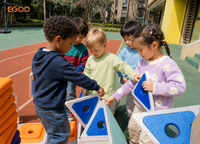 A little girl playing on a movable caster base cart assembled with Egoo Magniworld magnetic building pieces outdoors.