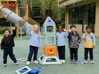 A young boy focusing on assembling a pedestal tower and funnel structure using Egoo Magniworld magnetic shapes on the playground.